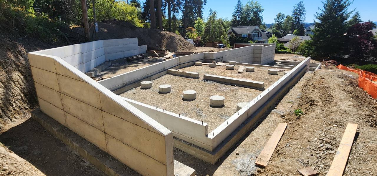 Concrete foundation footprint with curved and stepped walls on a hillside